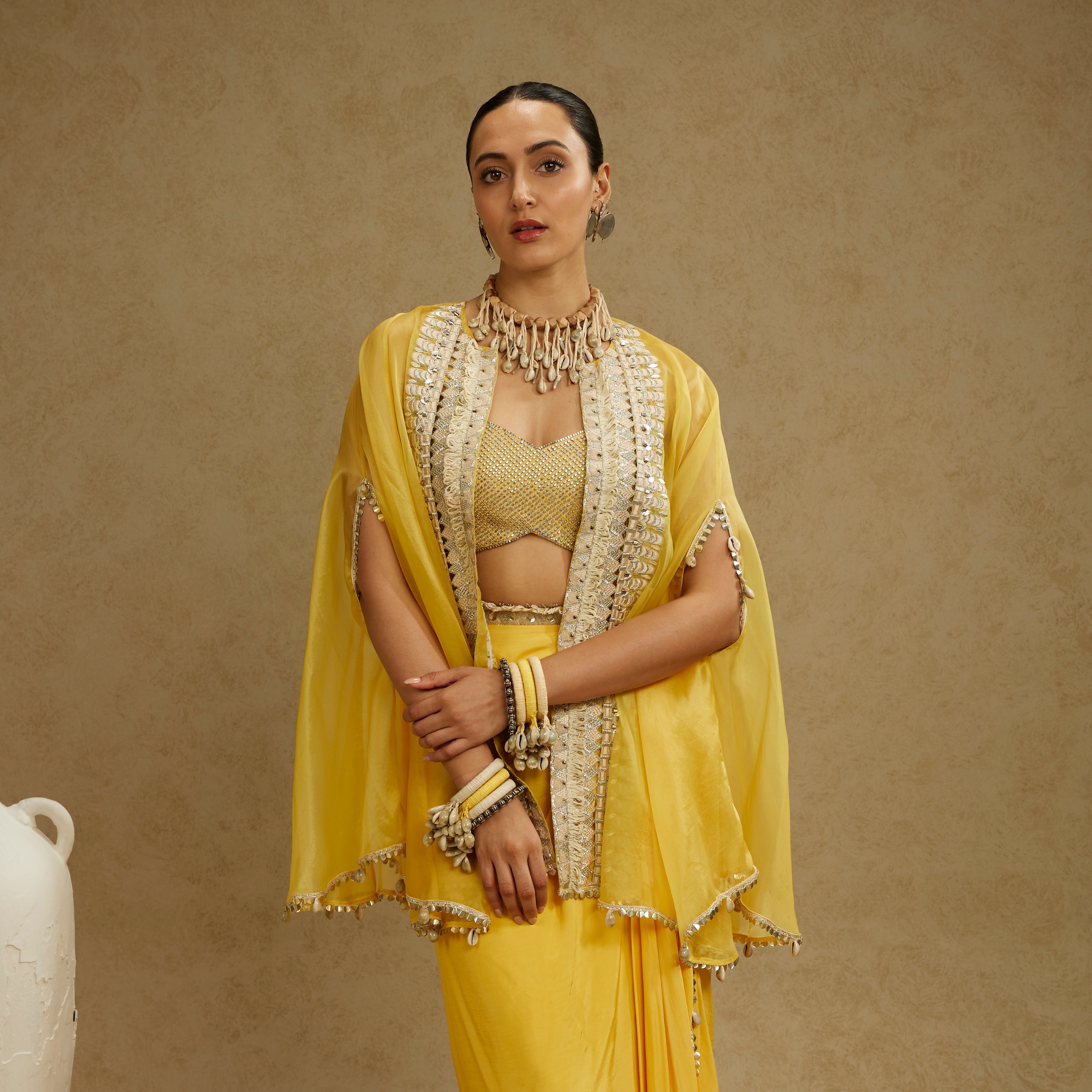 Metal Embellished Bustier Paired With Organza Cape And Yellow Drape Skirt
