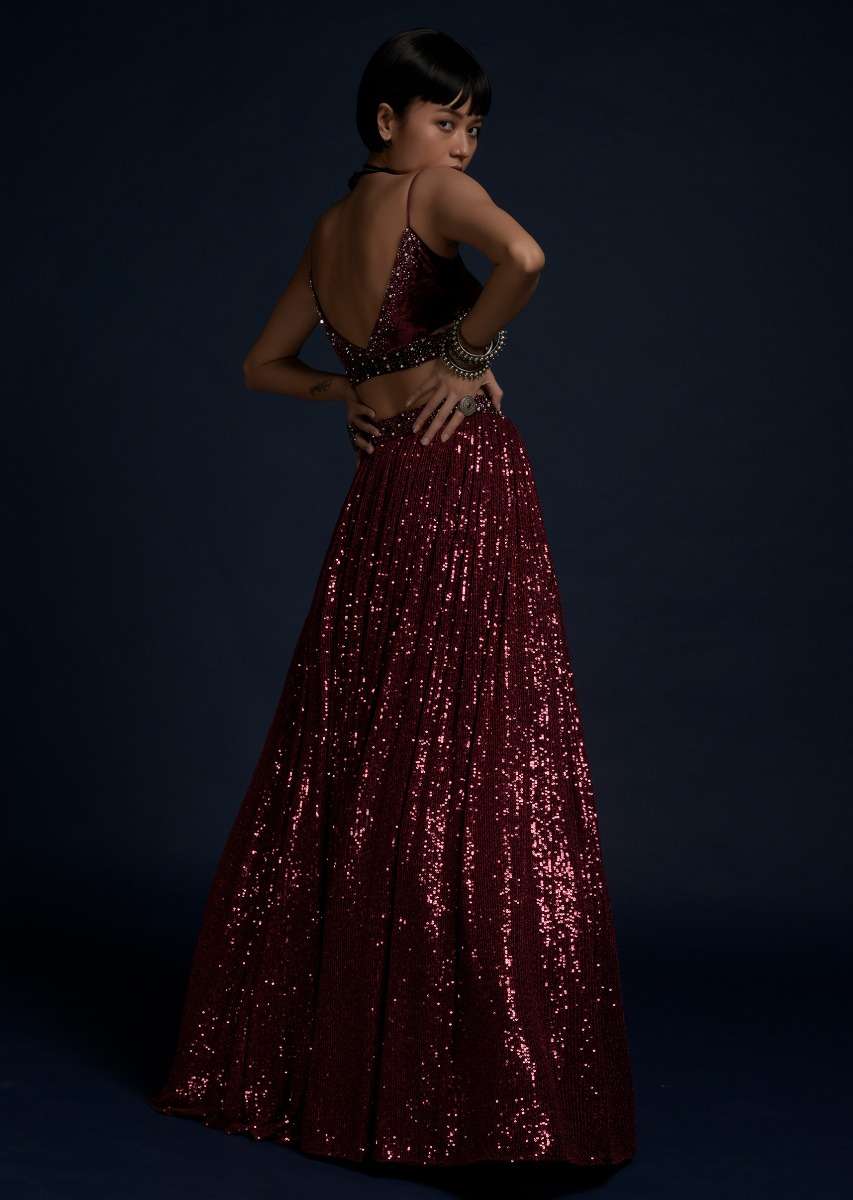 Burgundy Lehenga Embellished In Sequins With A Velvet Crop Top And Matching Belt Bag